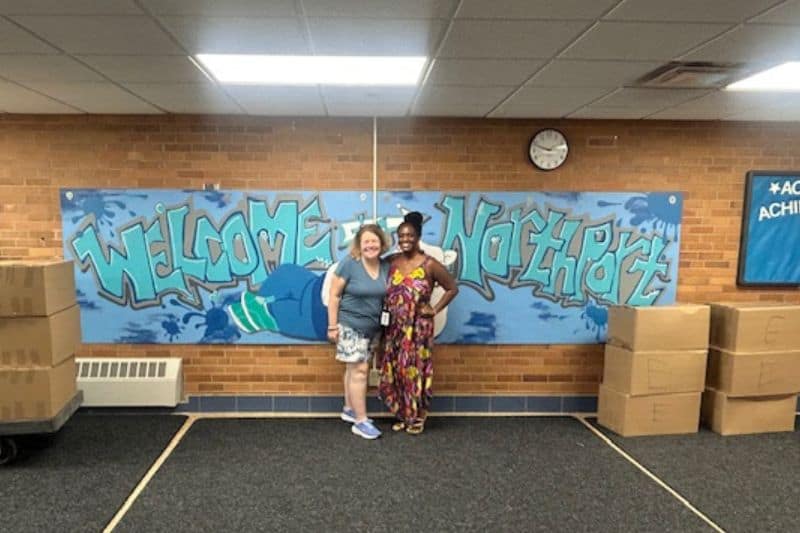backpack giveaway Chaz Sandifer and teacher at backpack giveaway event